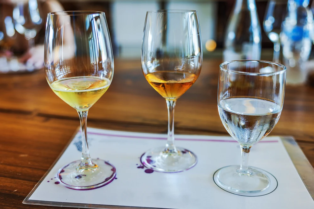 Vergleich der Farbe von Weißwein, Orange Wine und Wasser